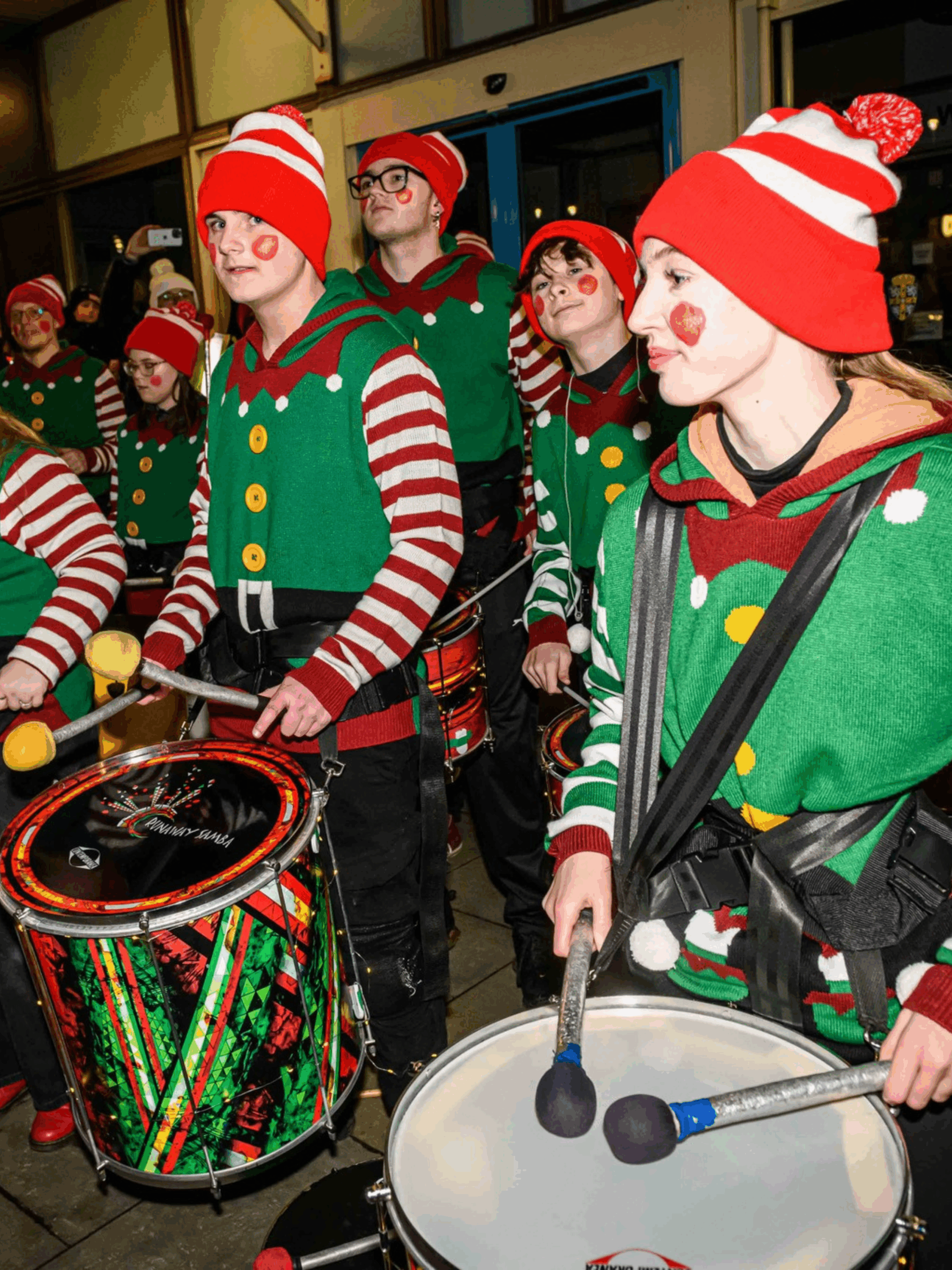 Christmas Parade with various musical instruments played by people in colourful elf costumes